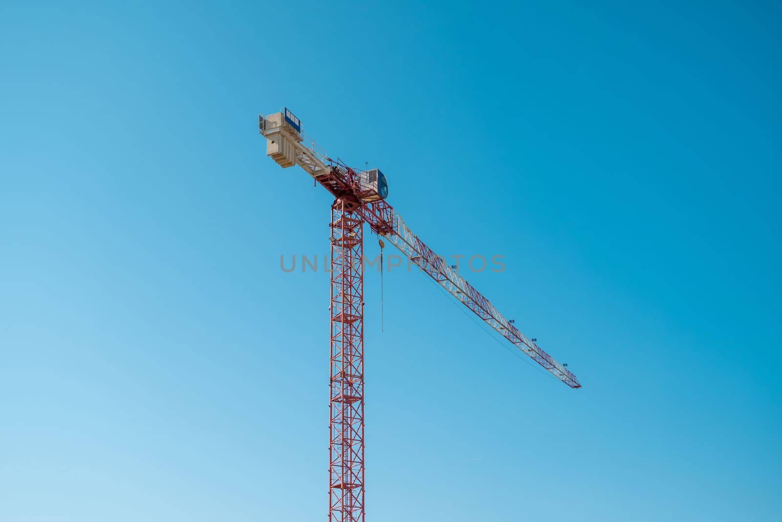 Construction crane in front of cloudless sunny blue sky
