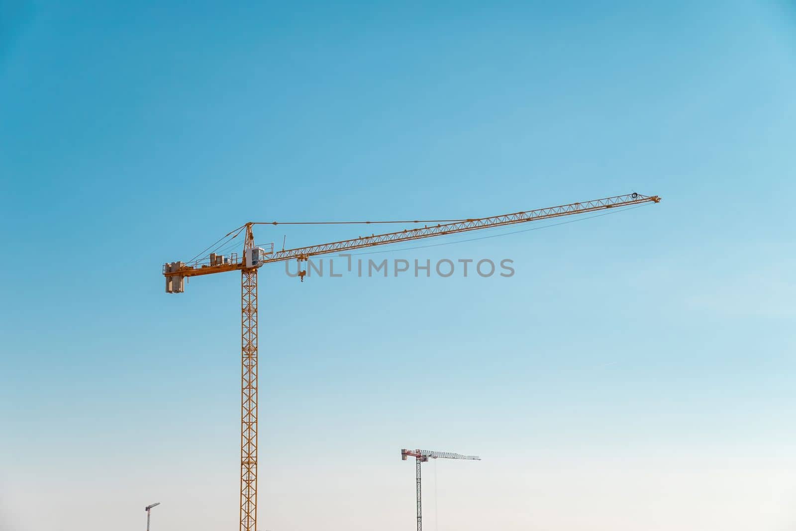 Construction crane in front of cloudless sunny blue sky