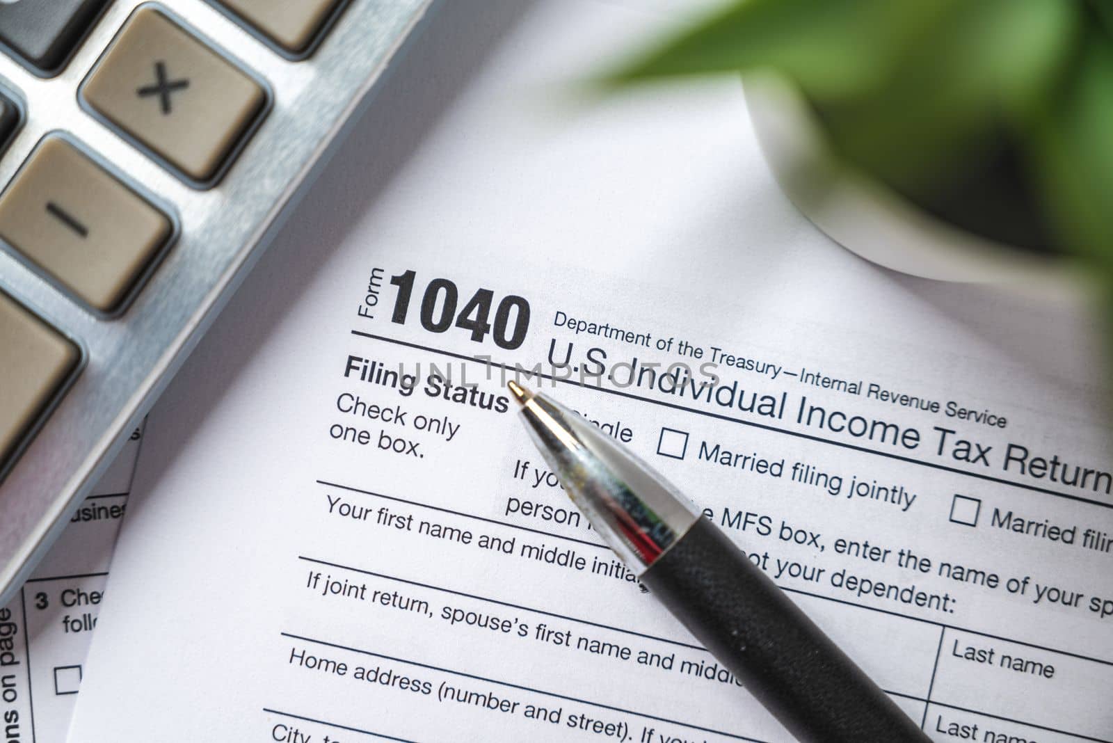 Financial time tax return forms with pen and calculator