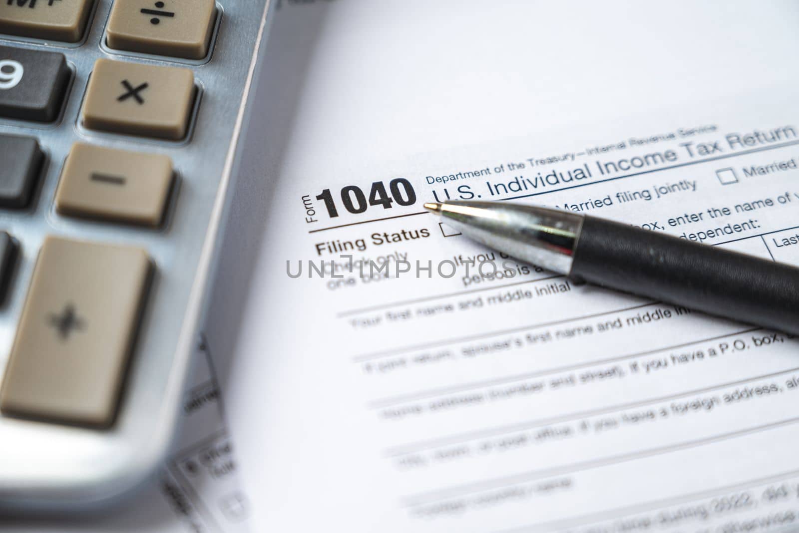 Financial time tax return forms with pen and calculator