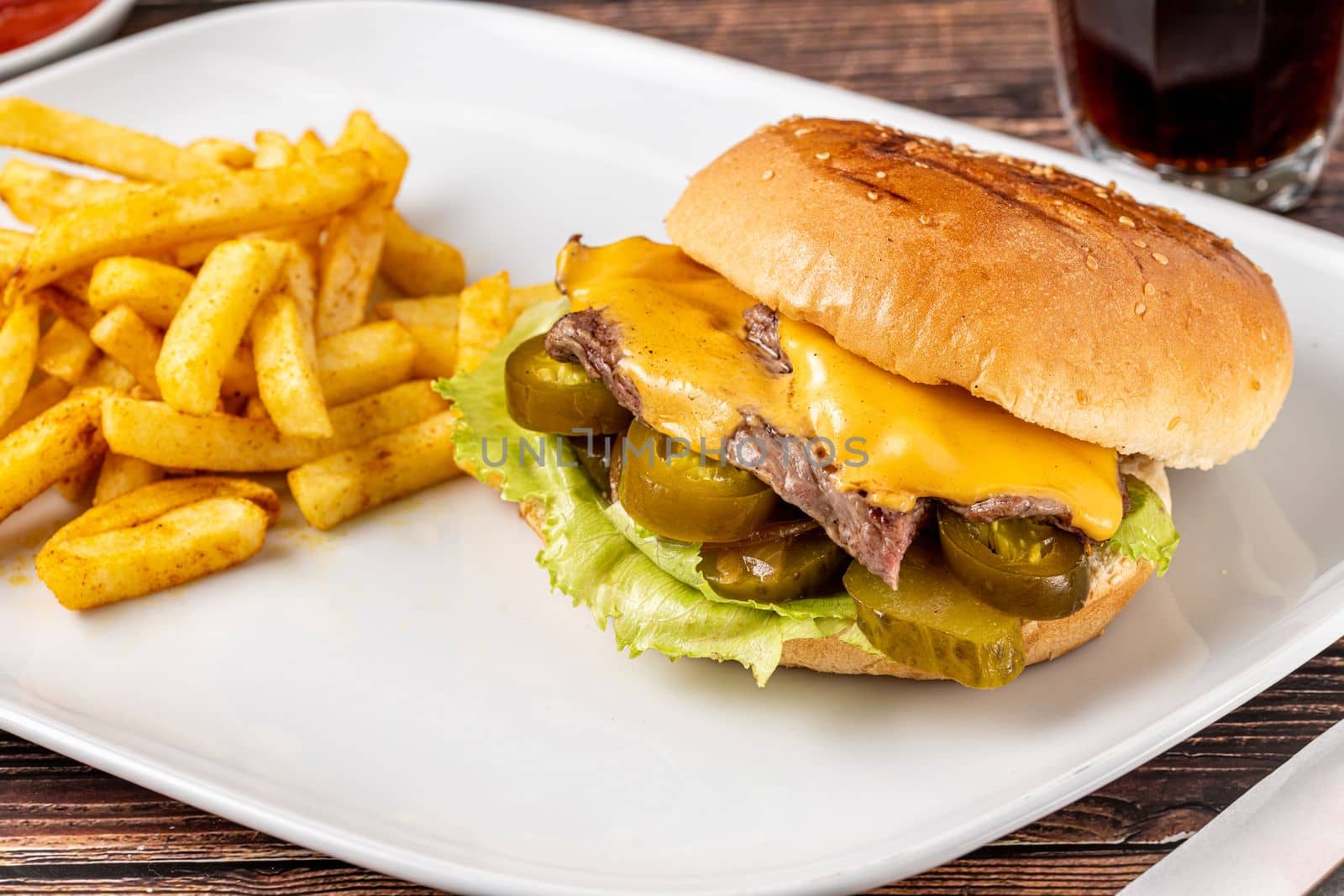 Delicious beef burger with french fries, onion rings and sauces