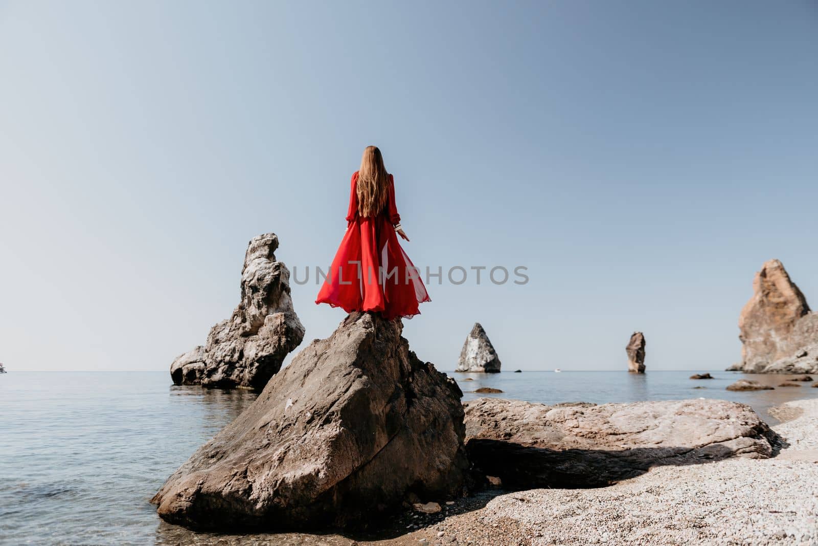 Woman travel sea. Happy tourist taking picture outdoors for memories. Woman traveler looks at the edge of the cliff on the sea bay of mountains, sharing travel adventure journey.
