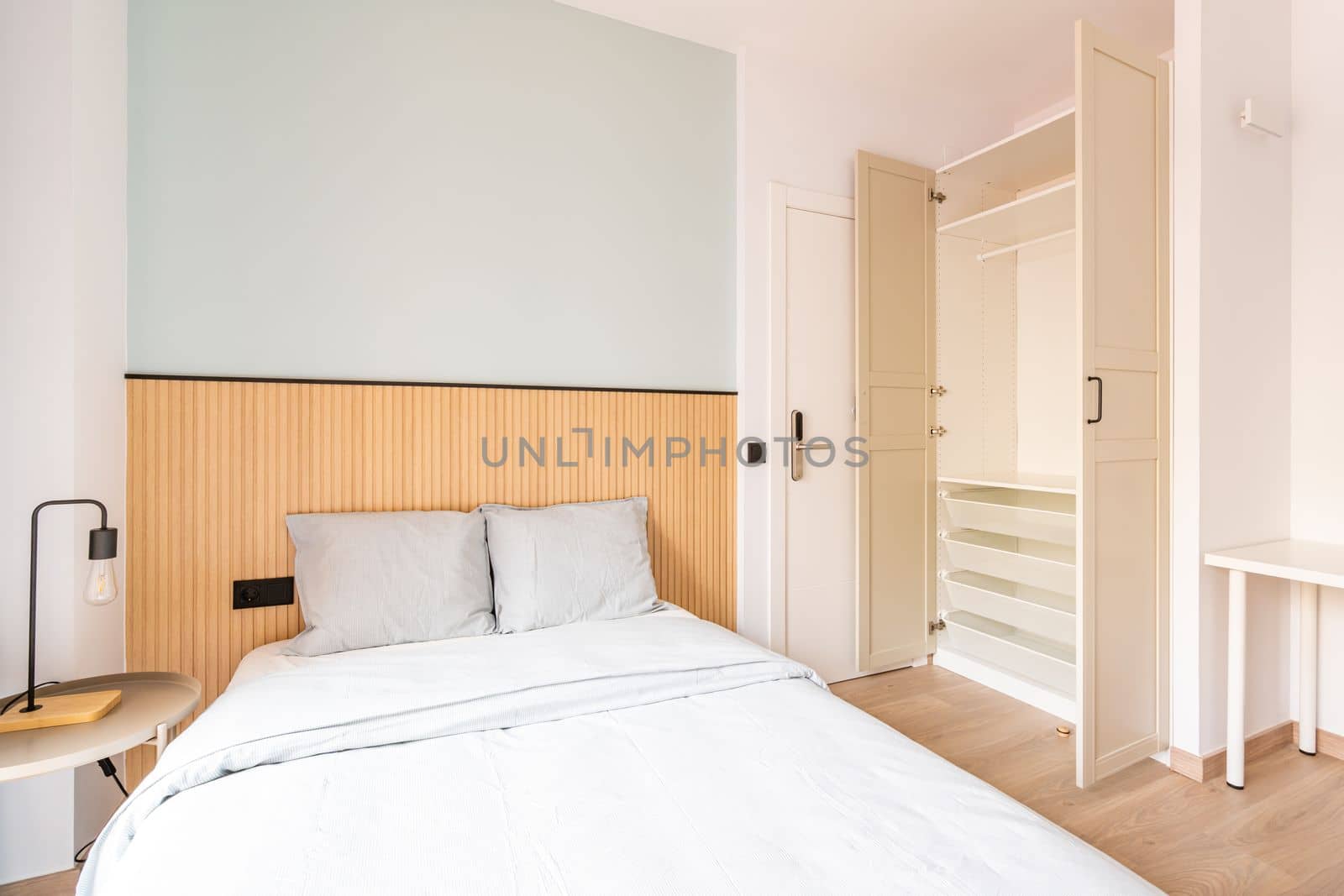 Hotel room with large double bed, beautiful linens. There is wood paneling on wall at headboard. Large wardrobe for clothes and shoes. The door is electronically locked with digital code. by apavlin