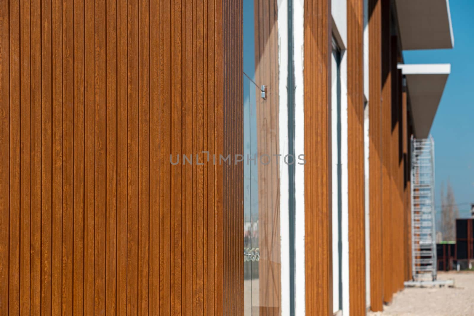 The shopping mall with its facade covered with wood-patterned PVC panels by Sonat