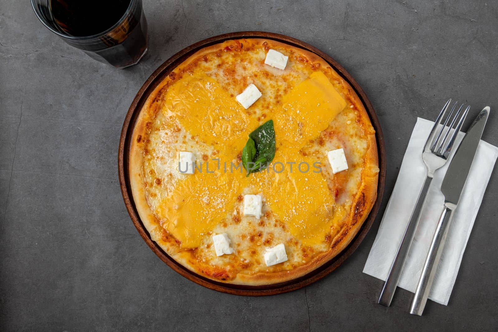 Italian pizza with four cheeses and lots of mozzarella on a cutting board by Sonat