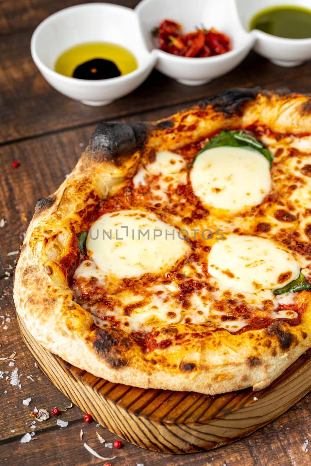 Italian pizza with four cheeses and lots of mozzarella on a cutting board by Sonat