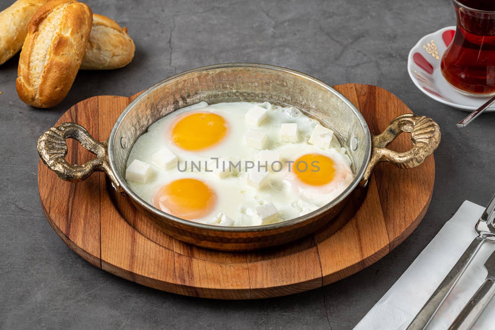 Sunny Side Up Eggs with feta cheese in a copper pan by Sonat