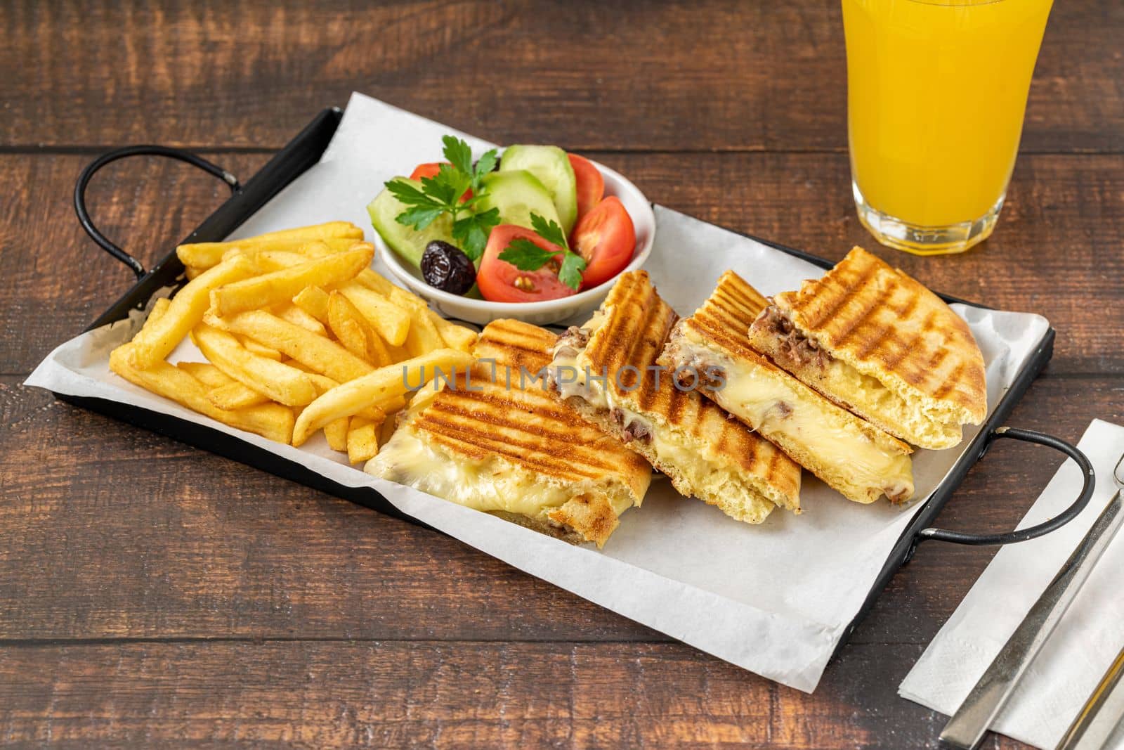 Turkish toast with roasted meat served with olives, cucumbers and tomatoes