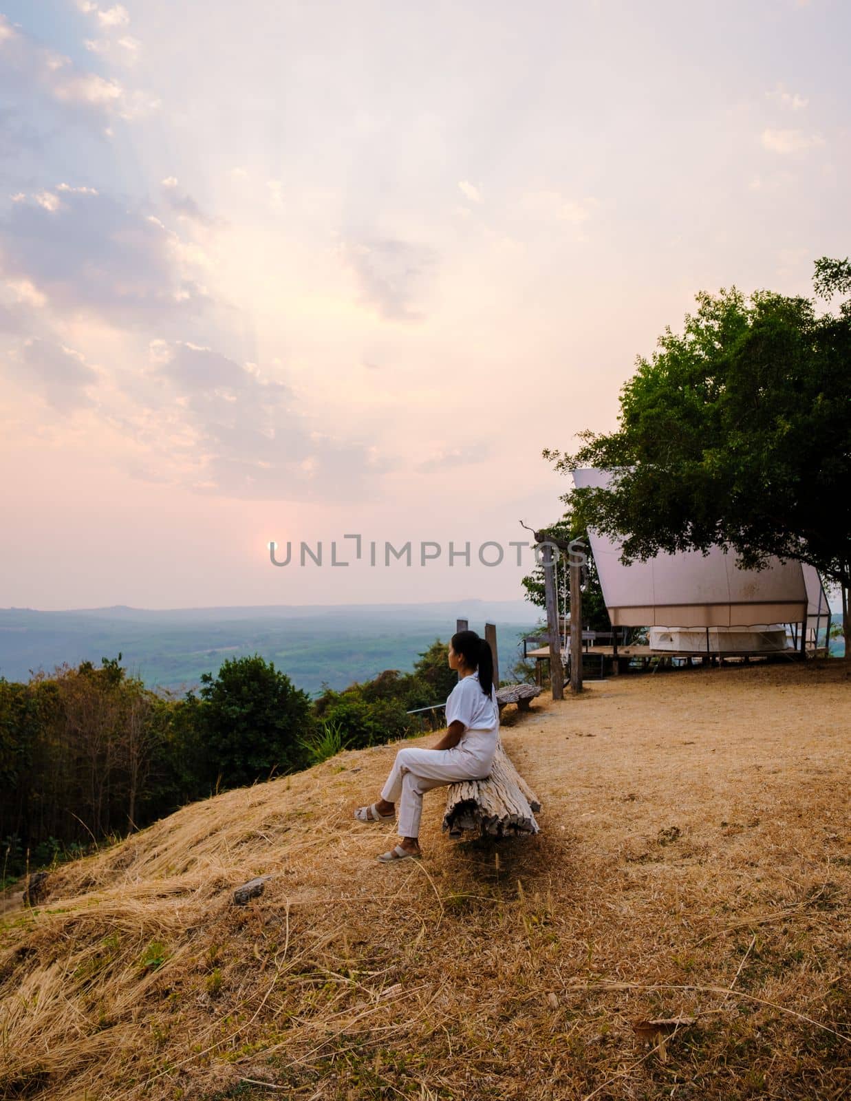 Thai women watching sunset in the mountains of Northern Thailand by fokkebok