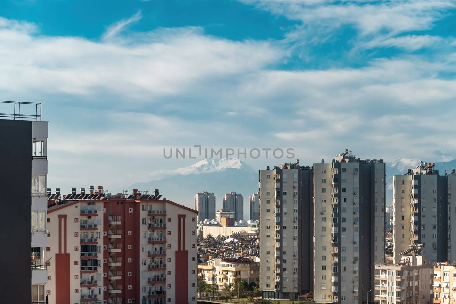 Snowy mountain peak visible through city buildings on a sunny day