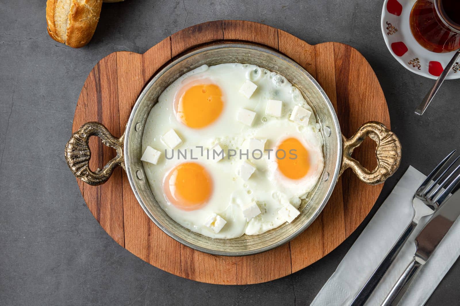 Sunny Side Up Eggs with feta cheese in a copper pan