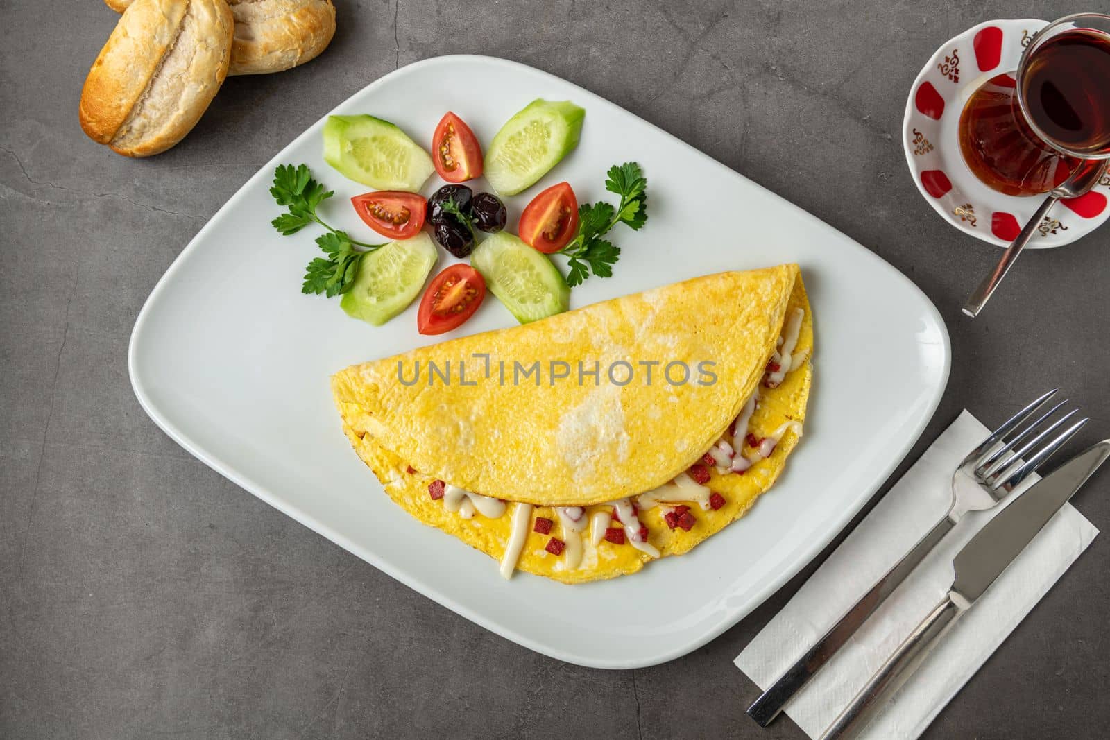 Omelet with feta cheese and Turkish sausage on a white porcelain plate by Sonat