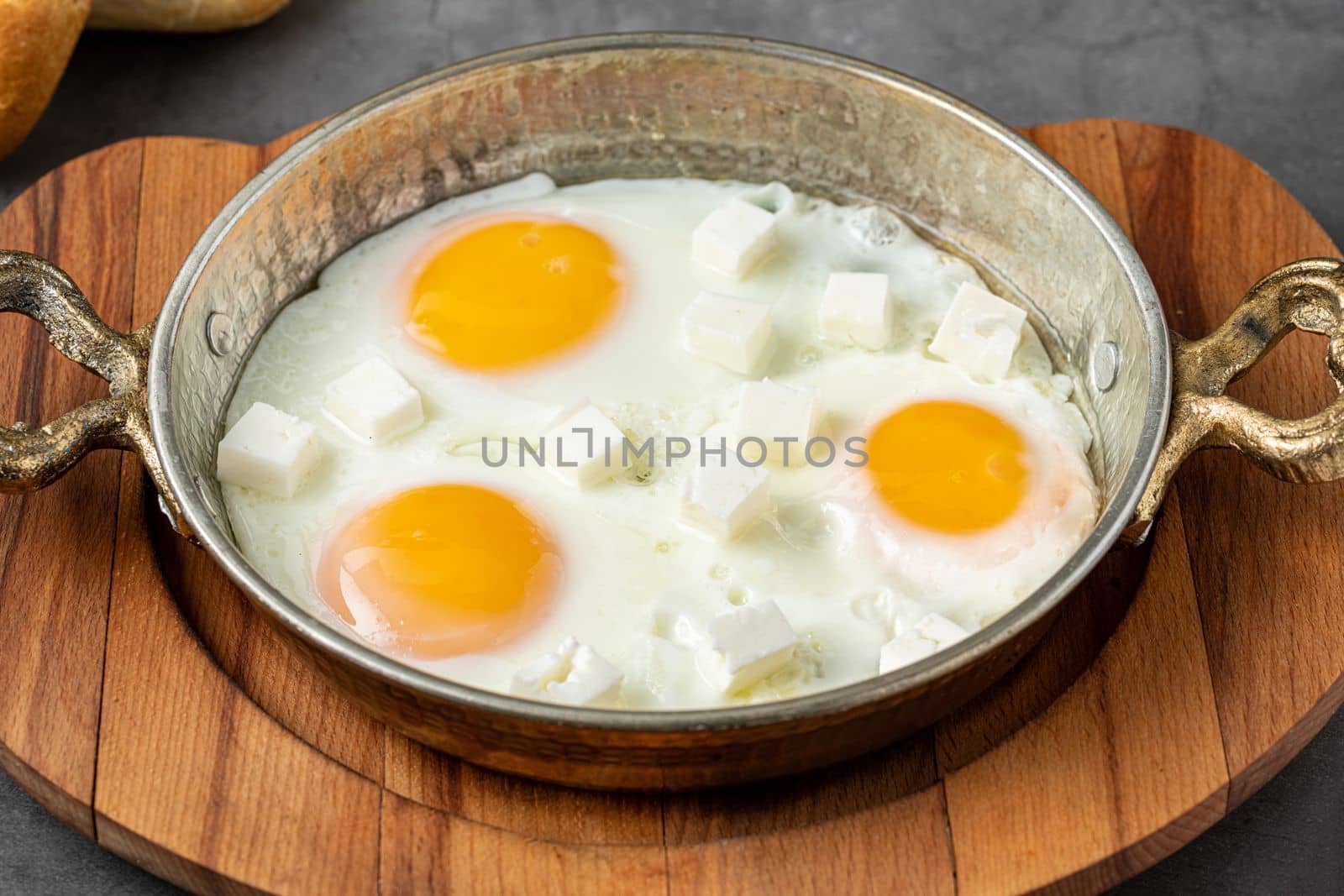 Sunny Side Up Eggs with feta cheese in a copper pan