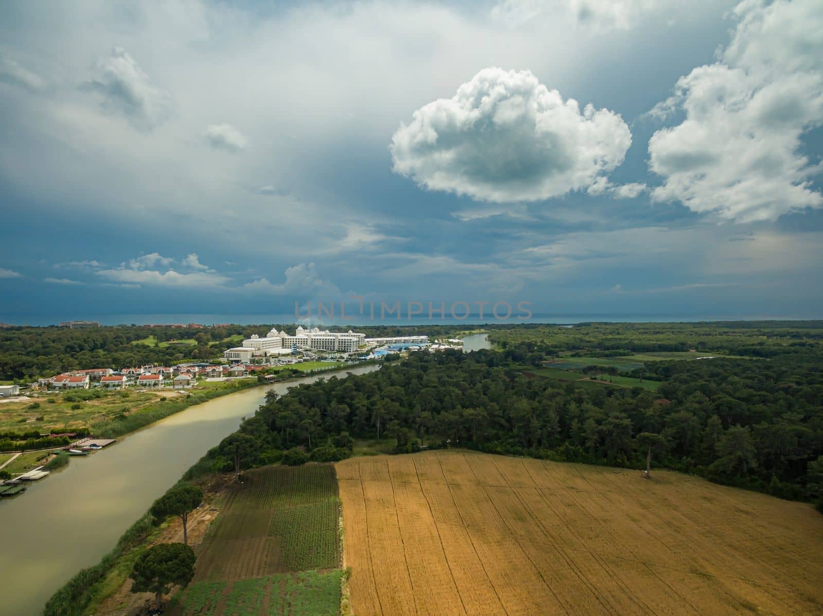 Aerial photo of vegetable field by the roadside leading to the city