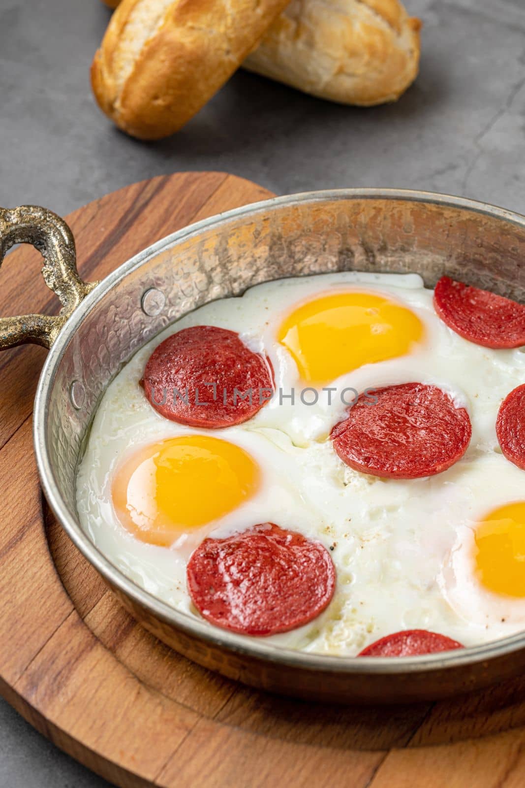 fried eggs with turkish sausage with bread and tea on dark stone table