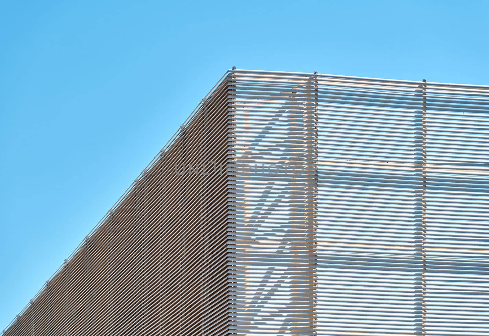 Spaced-mounted aluminum profiles covering the exterior of a building by Sonat