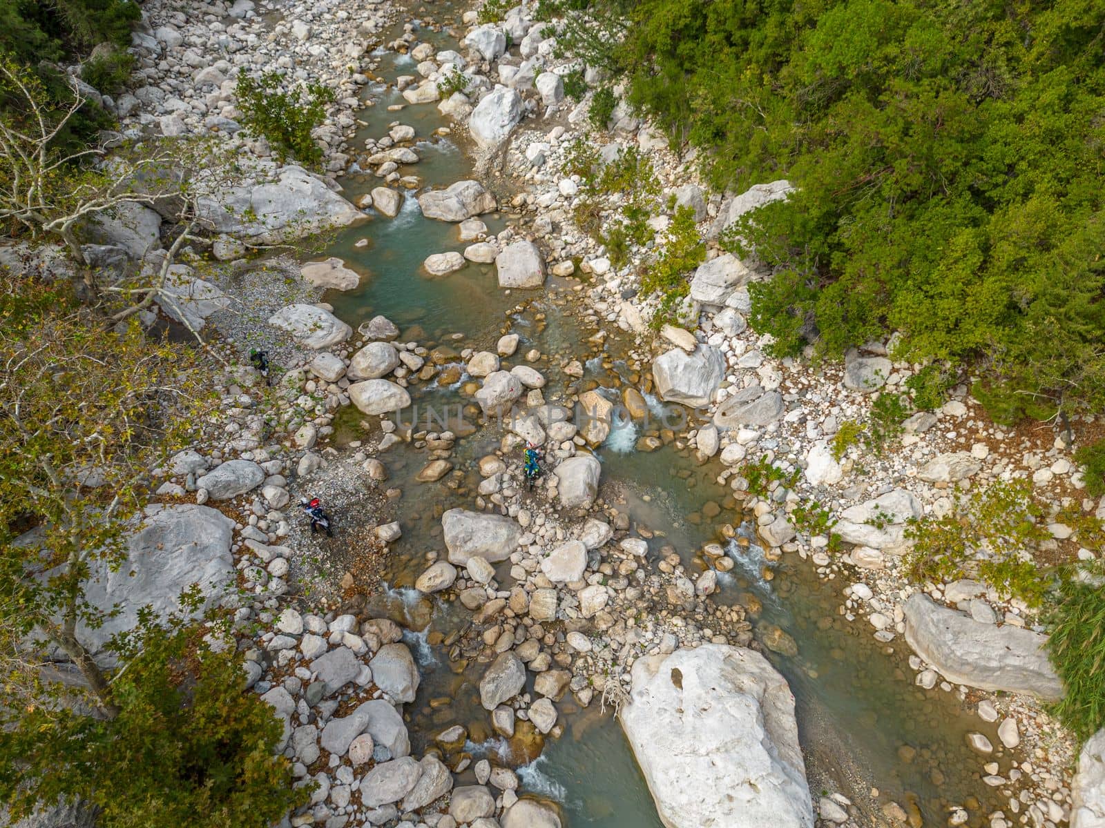 Cross country motorbike riders trying to go over cliffs in the river