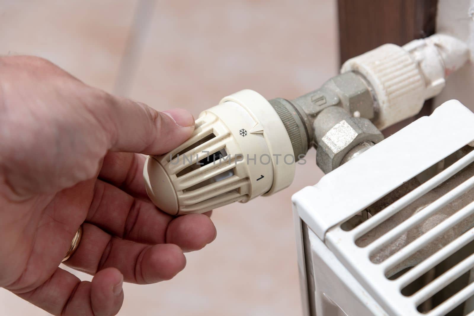 The hand that closes the radiator valve of the boiler in Europe, where there is a shortage of natural gas due to the Russian war