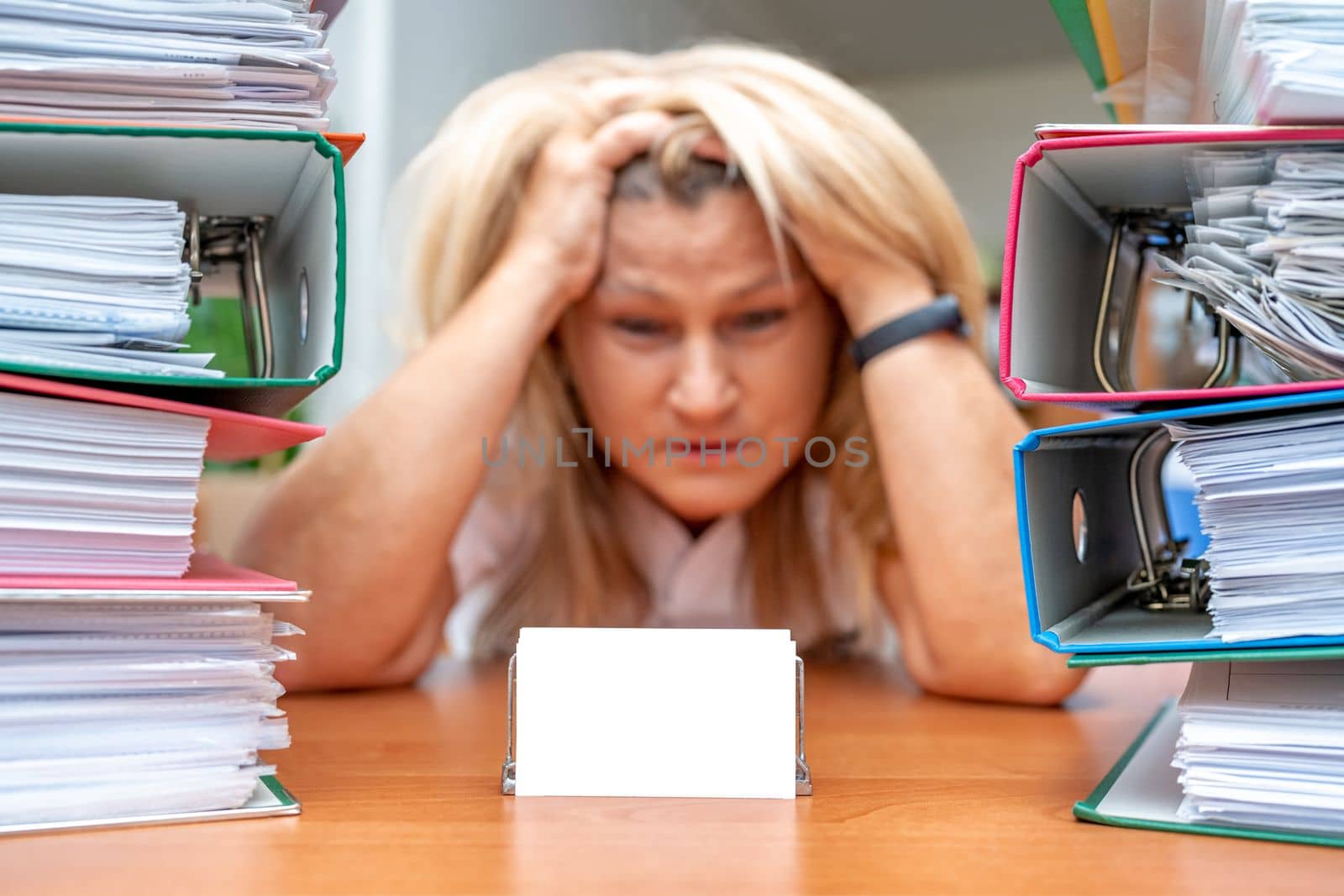 administrative worker under stress from the amount of work. Color folders with documents on the table. business card mockup by Edophoto