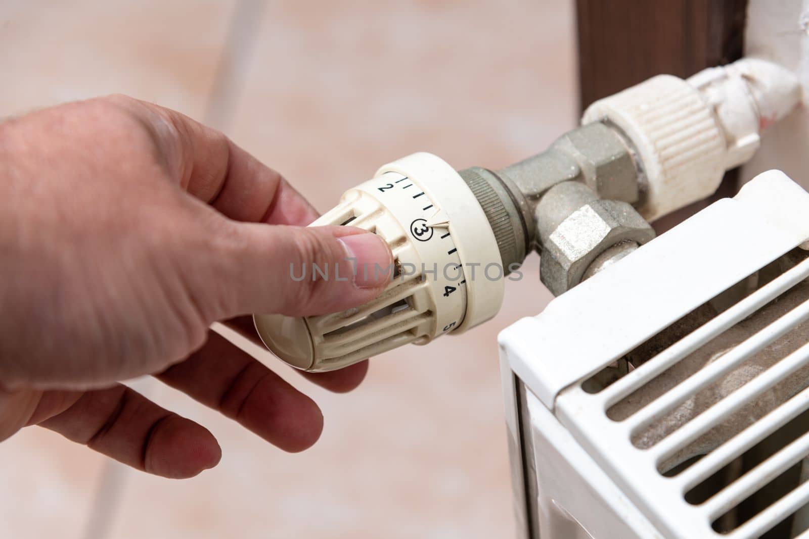 The hand that closes the radiator valve of the boiler in Europe, where there is a shortage of natural gas due to the Russian war by Sonat