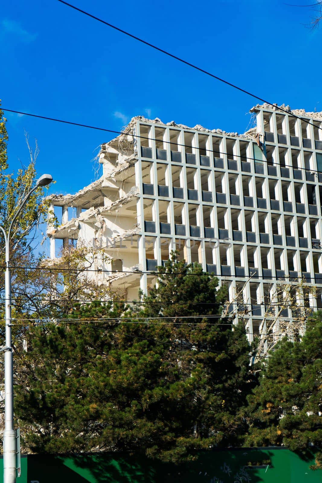 Background of process of demolition of building. Excavator breaking old house. by Zelenin