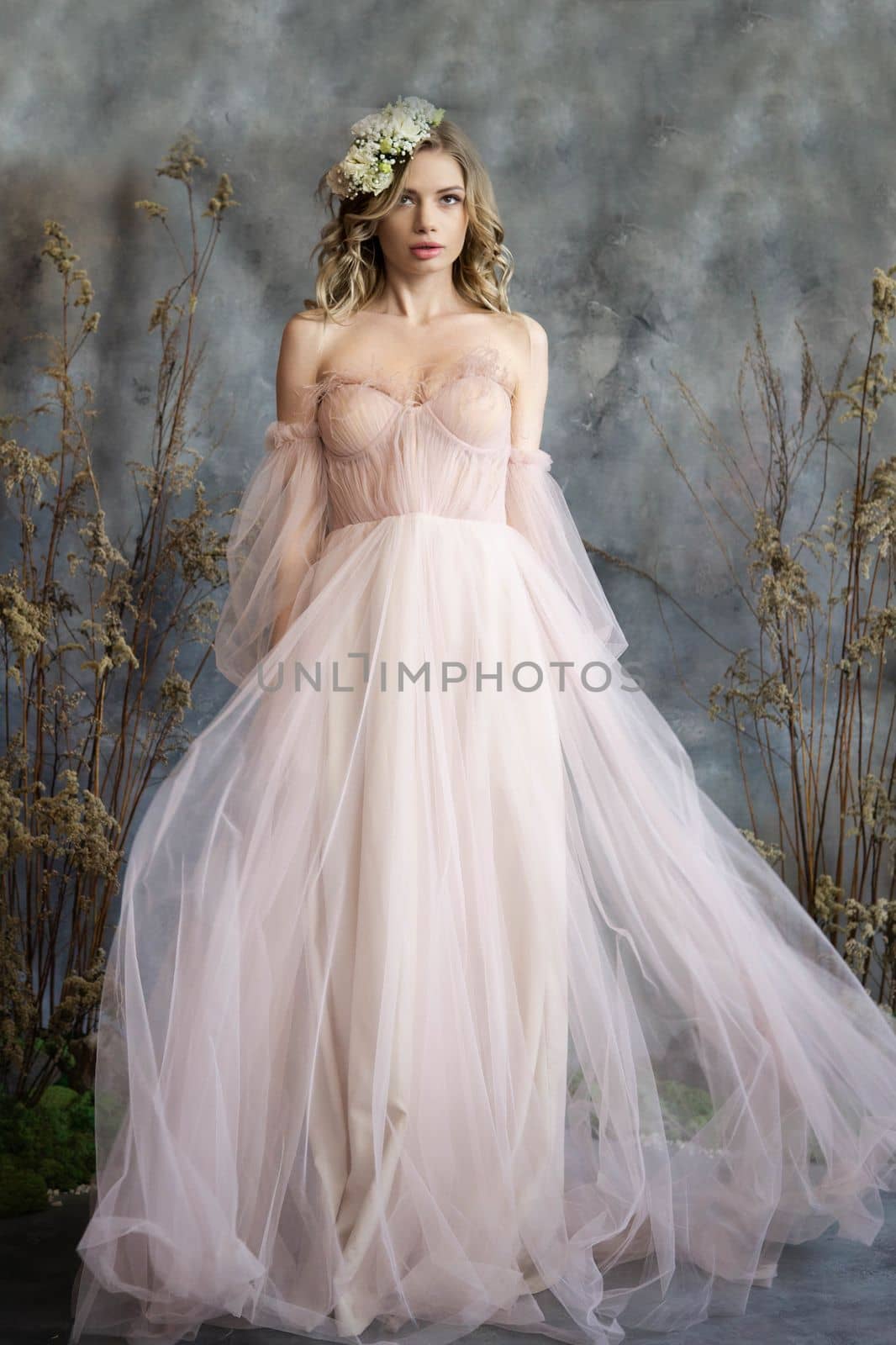 A young blonde in an airy tulle pink dress. Spring portrait of a woman