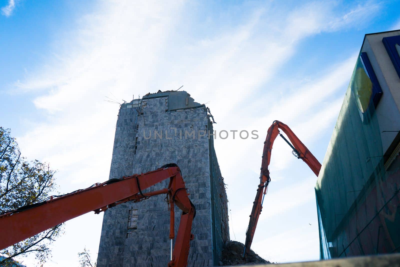 Background of process of demolition of a building. Excavator breaking old house.