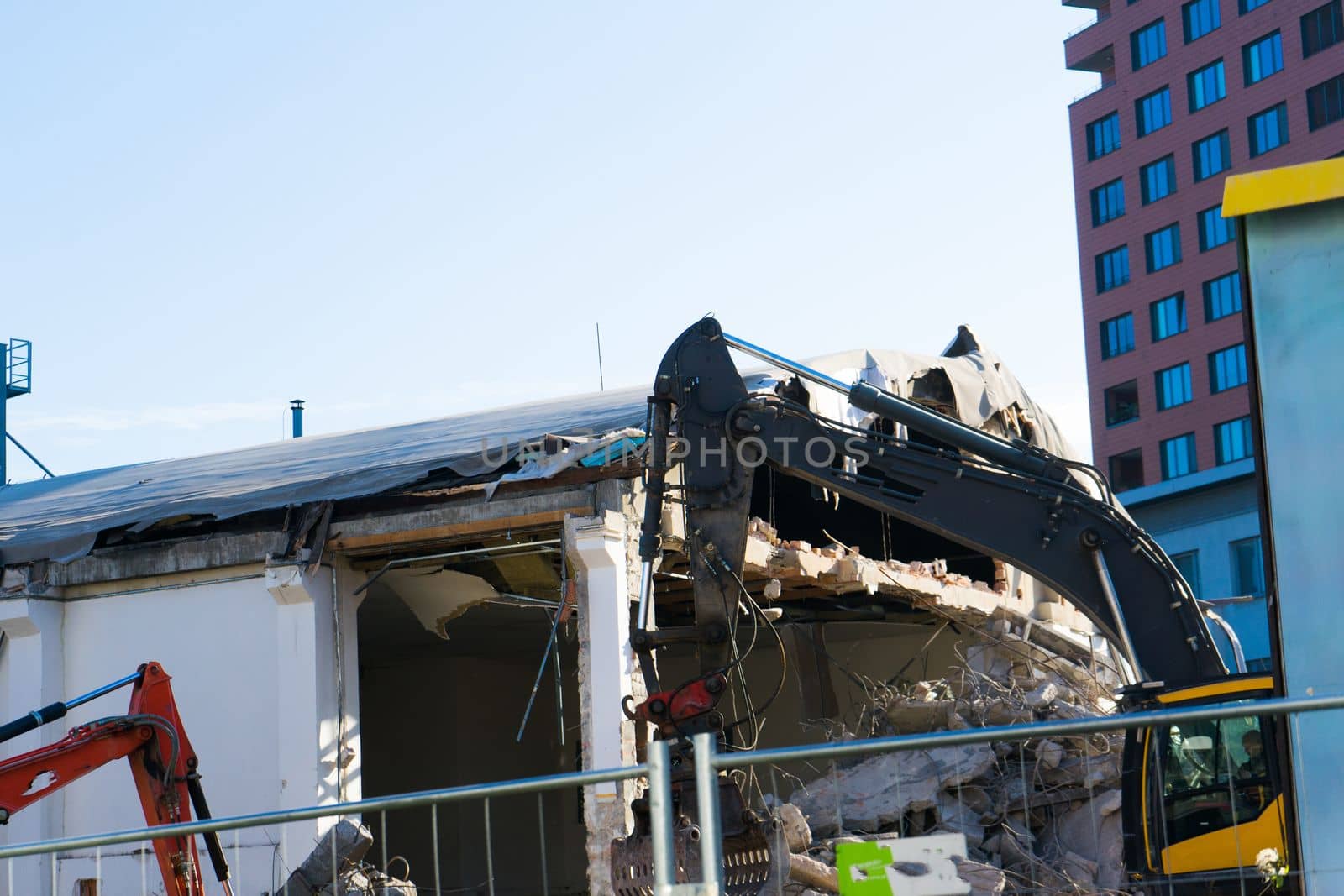 Background of process of demolition of a building. Excavator breaking old house.