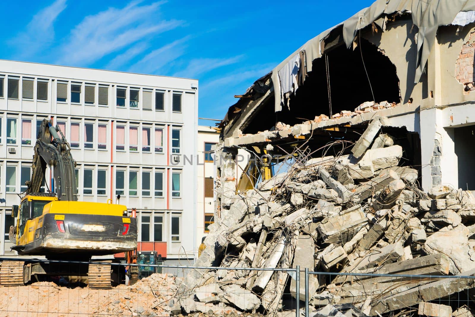 Background of process of demolition of a building. Excavator breaking old house.