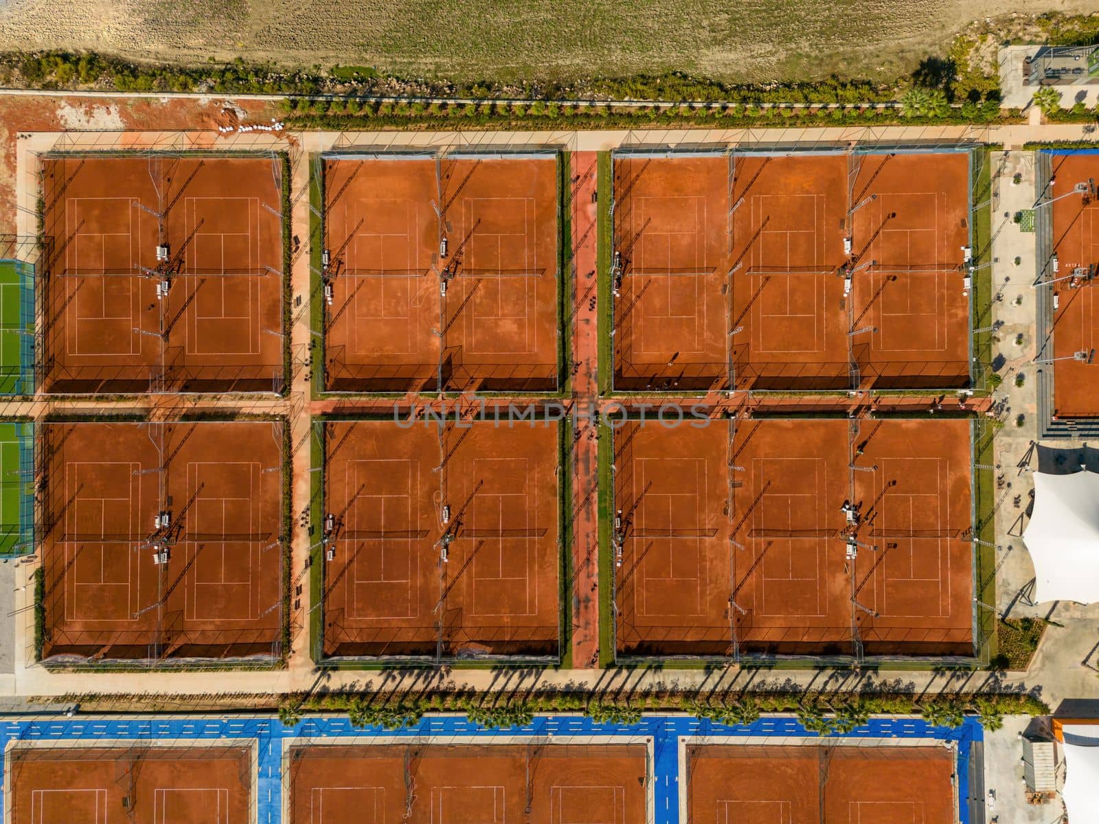 Aerial view of empty clay tennis court on a sunny day by Sonat