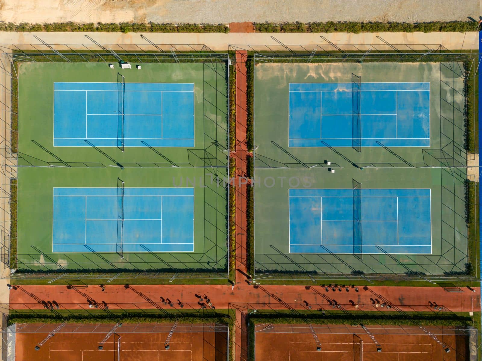 Aerial view of empty blue hard tennis court on a sunny day