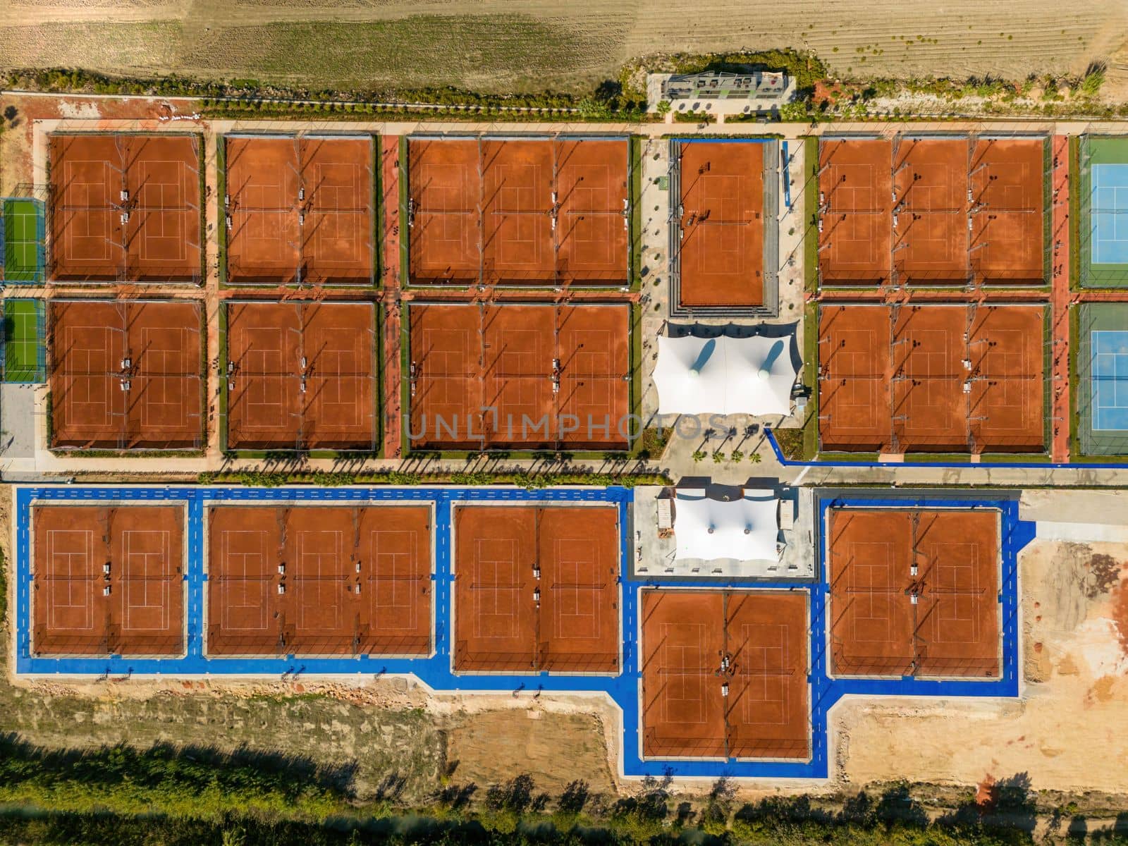 Aerial view of empty clay tennis court on a sunny day by Sonat