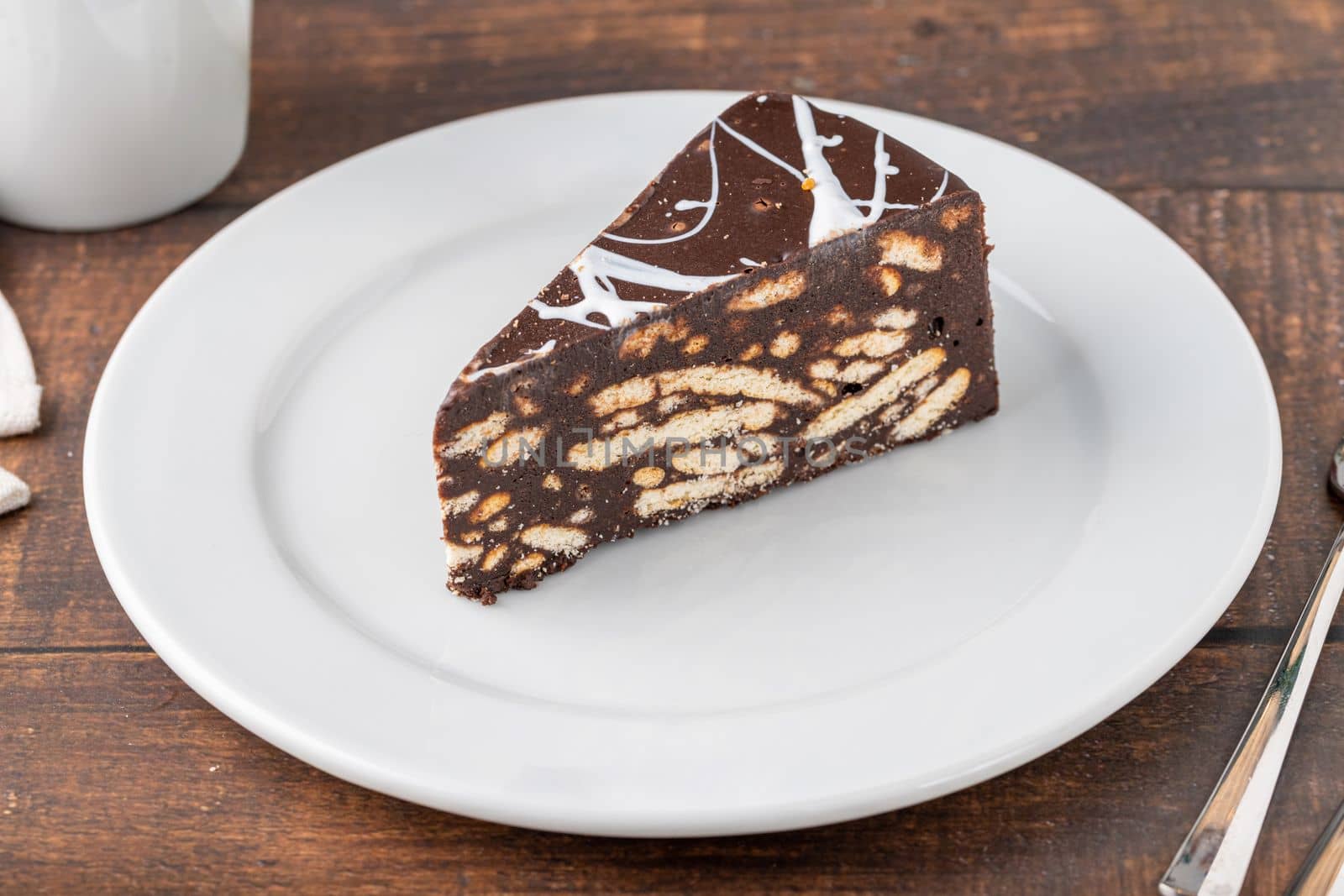 Chocolate mosaic cake on a white porcelain plate with filter coffee on the side by Sonat