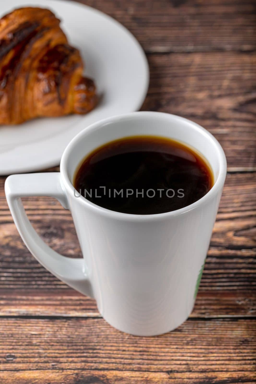 Relaxing filter coffee in white porcelain cup on wooden table