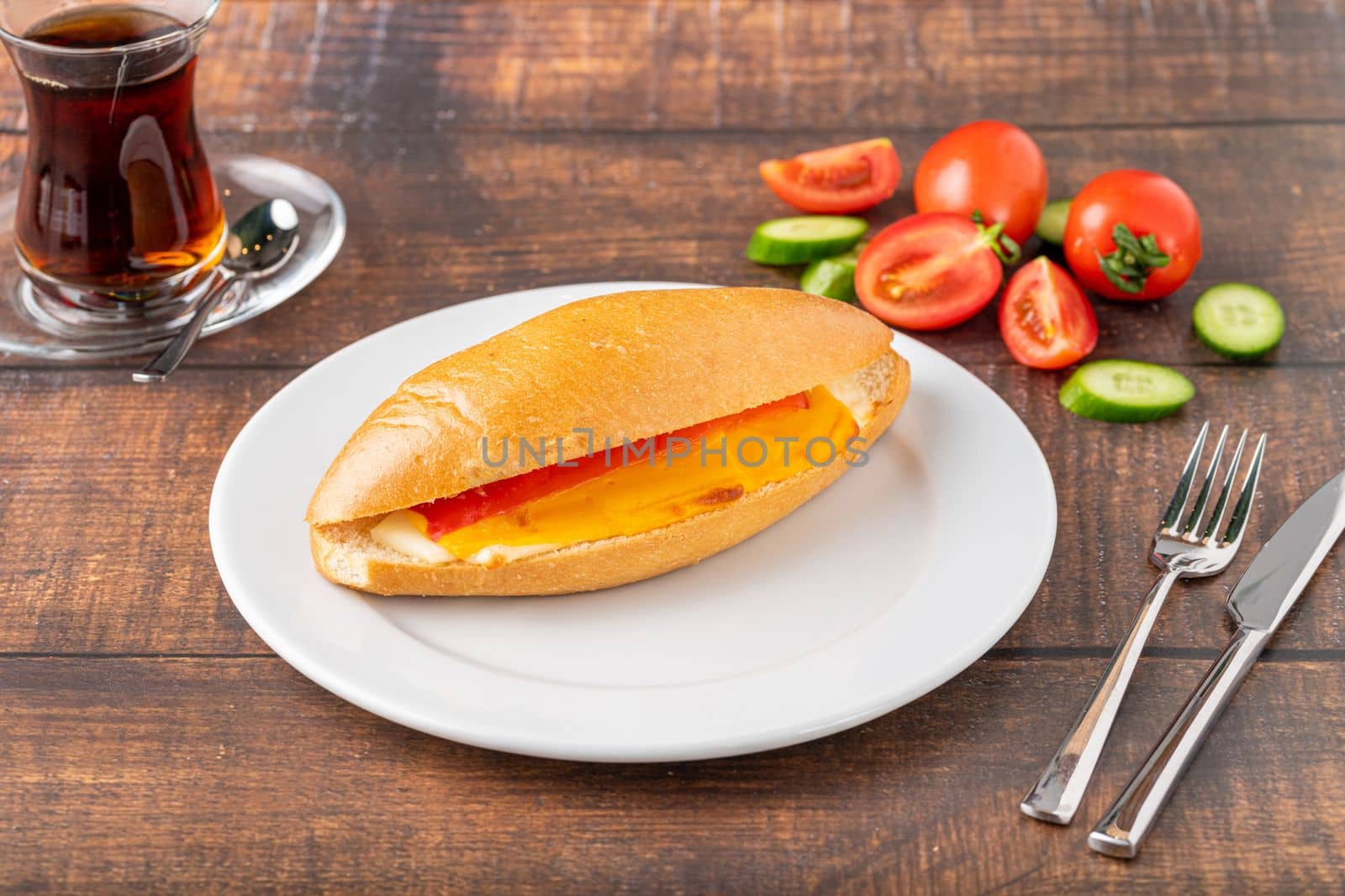 three cheese sandwich with tomato and cucumber on dark stone table by Sonat