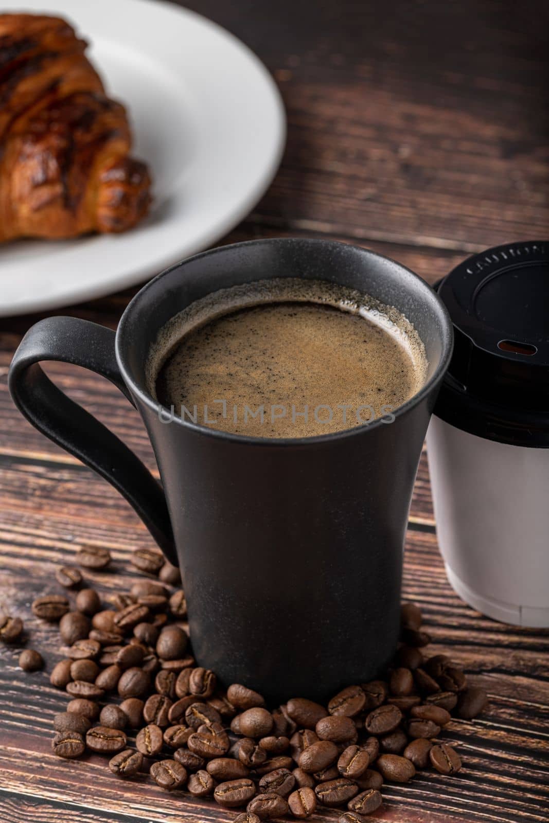 Relaxing americano coffee in black porcelain cup and take away cup on wooden table