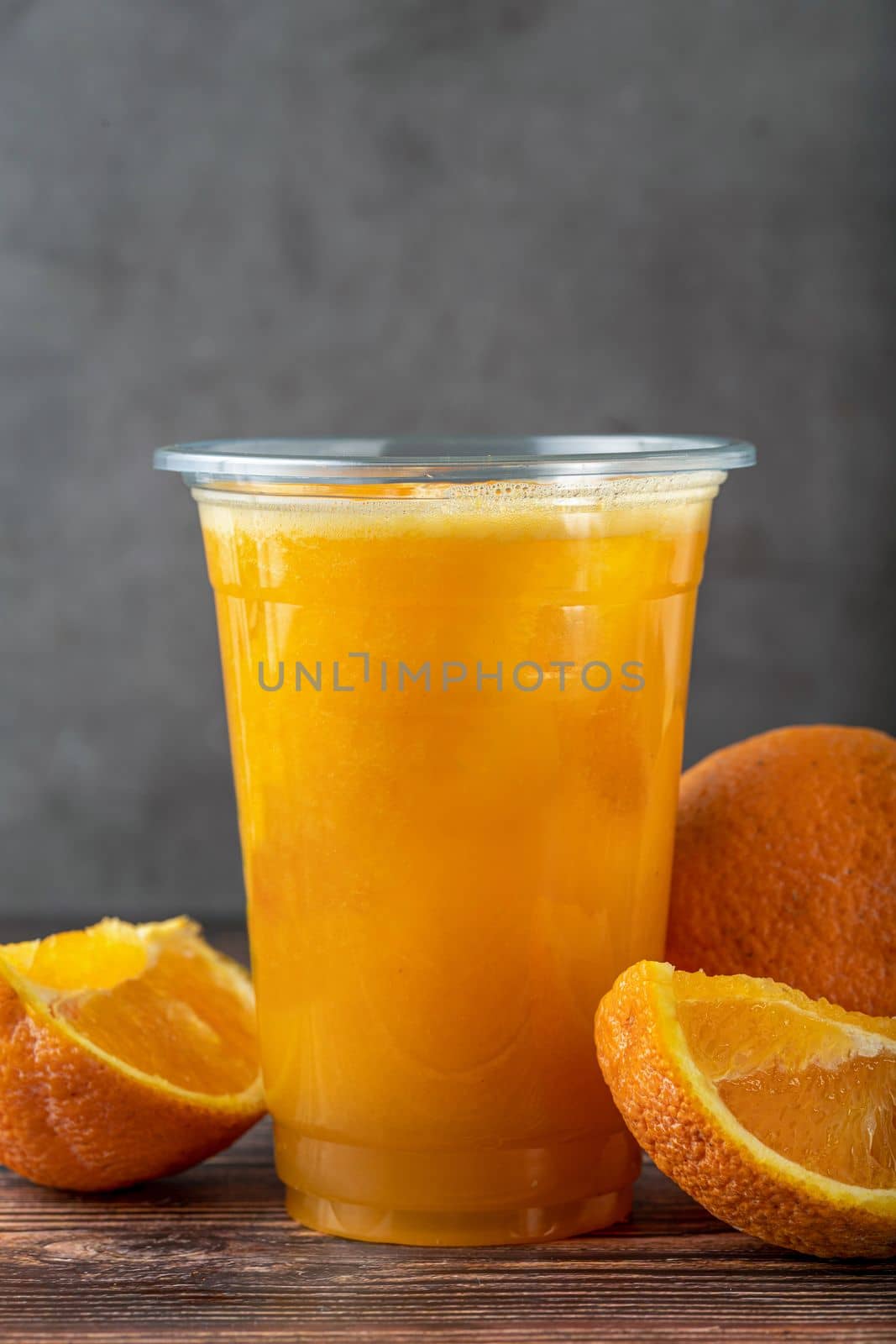 Freshly squeezed orange juice with ice cubes on wooden table