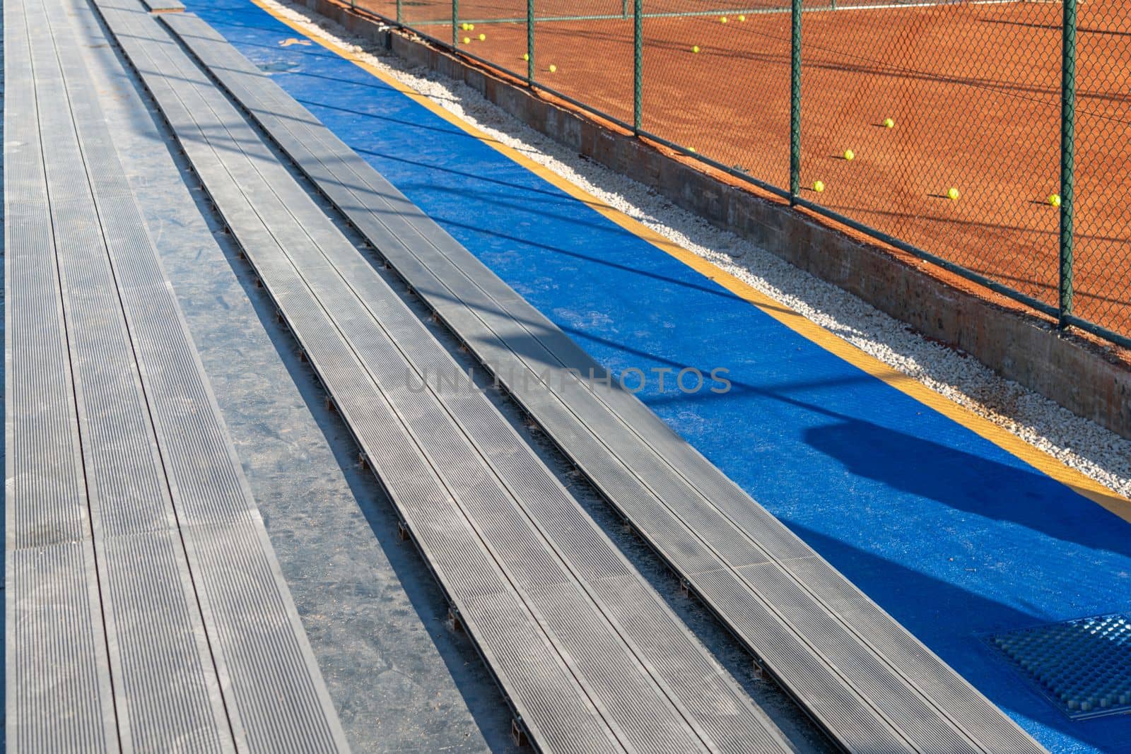 Seating area for spectators made with composite deck next to the tennis court