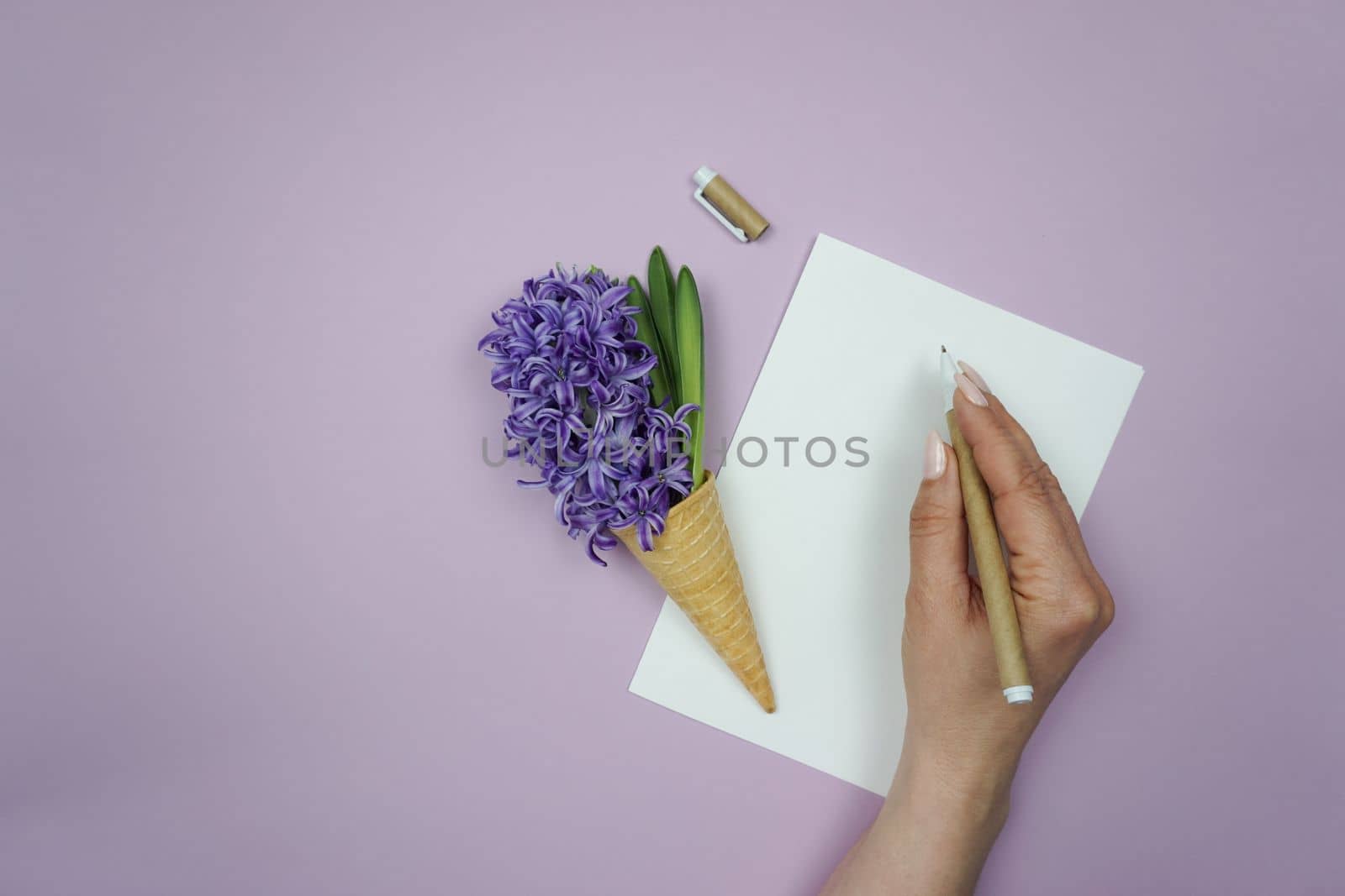 A woman's hand writes on a white sheet of paper. by Spirina