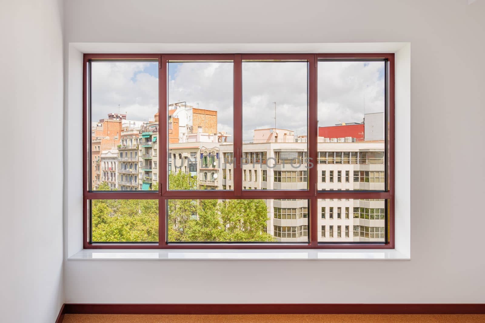 Large window in the room with a wide window sill. Window in plastic brown frame. Through the window you can watch what is happening on the street and the neighboring houses opposite. by apavlin