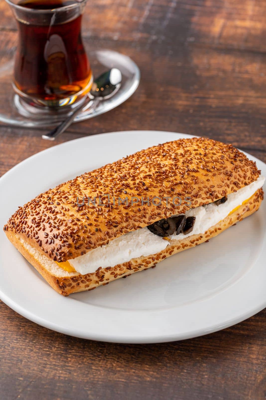 Olive and cheese sandwich with Turkish tea on wooden table by Sonat