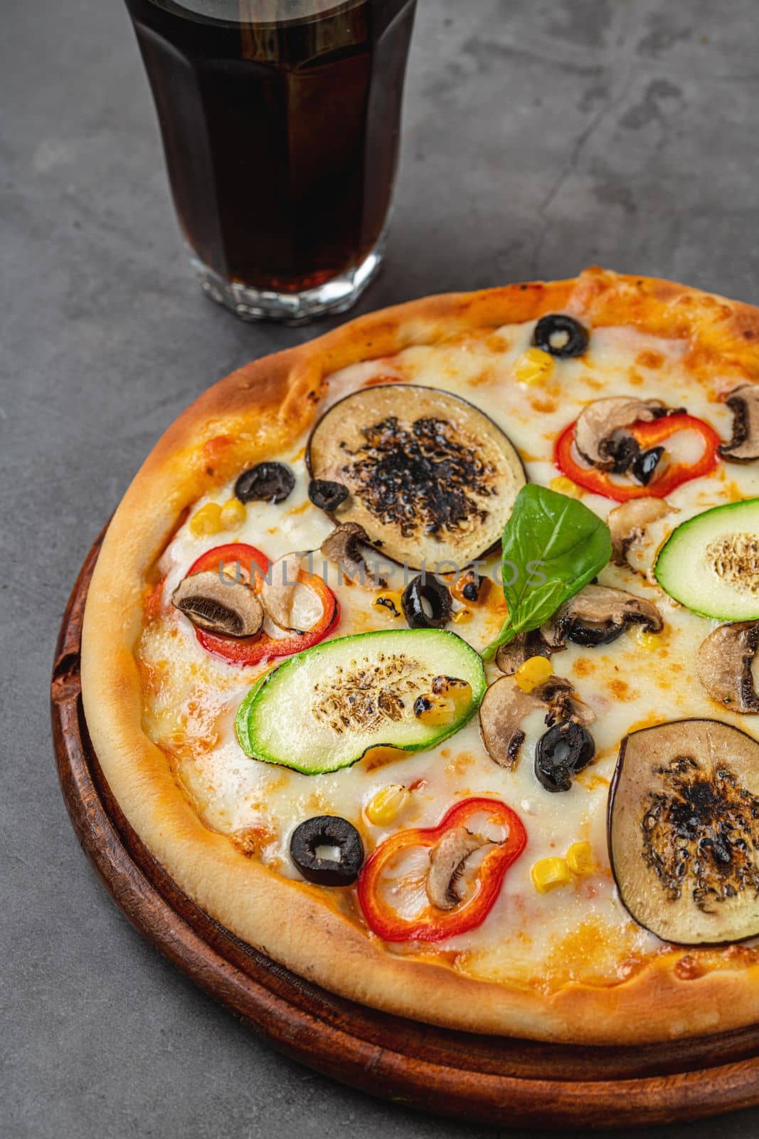 Vegetarian pizza with eggplant, zucchini and mushrooms on dark stone table by Sonat