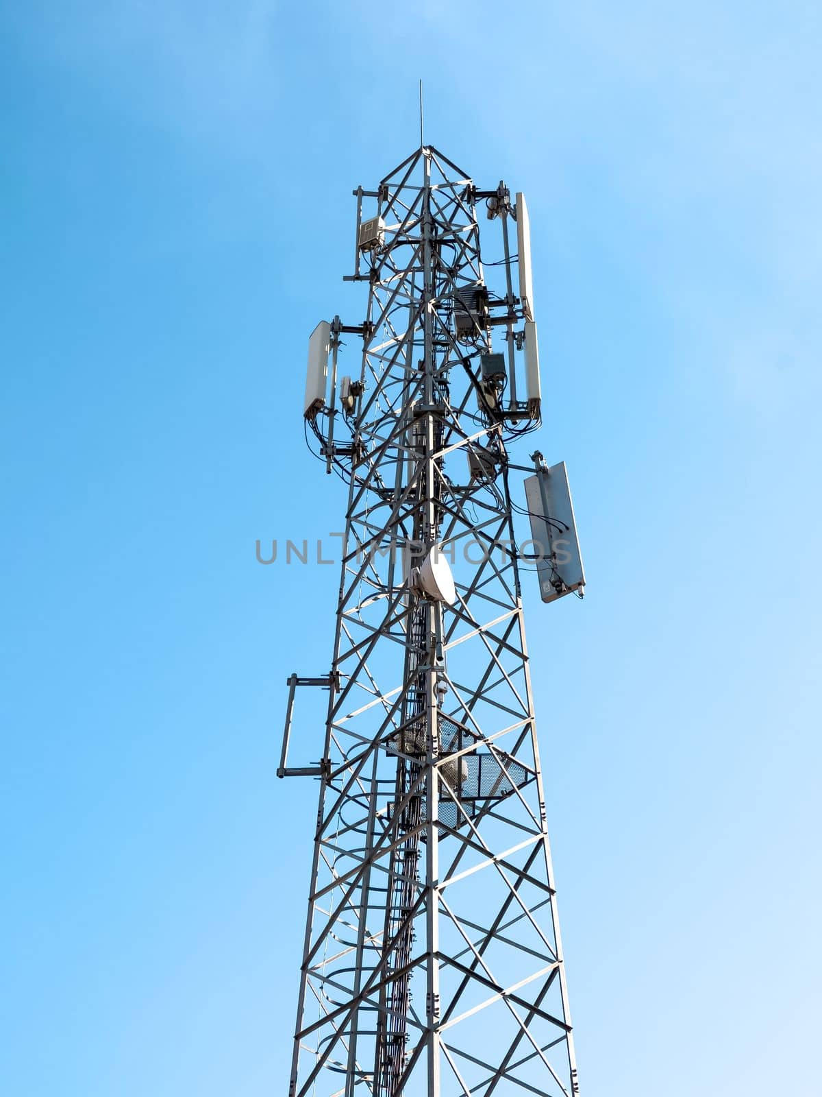 Telecommunication signal tower emitting telephone and television signals on a sunny day by Sonat