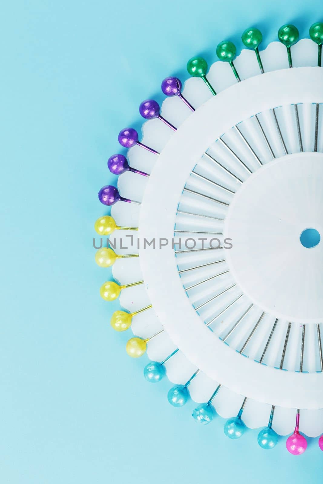 A set of multicolored needles pins in a round platform by AlexGrec