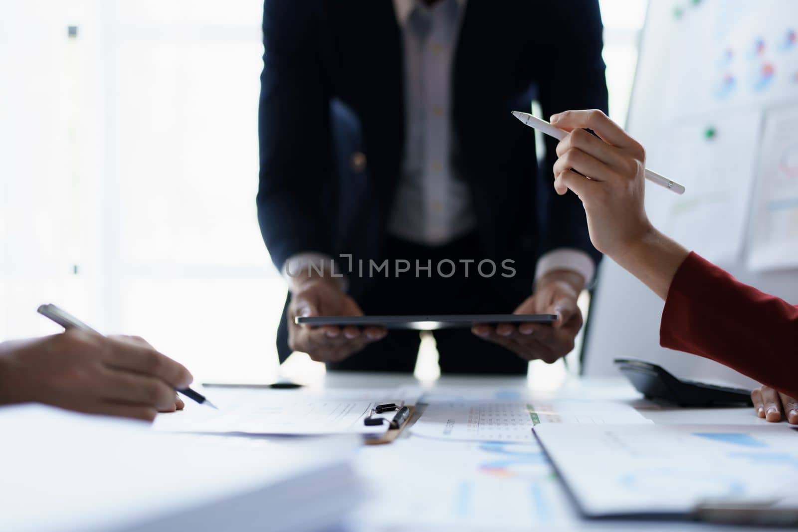 Team business adviser meeting to analyze and discuss the situation on the financial report n the meeting room with using tablet, calculator, documents, computer laptop in work