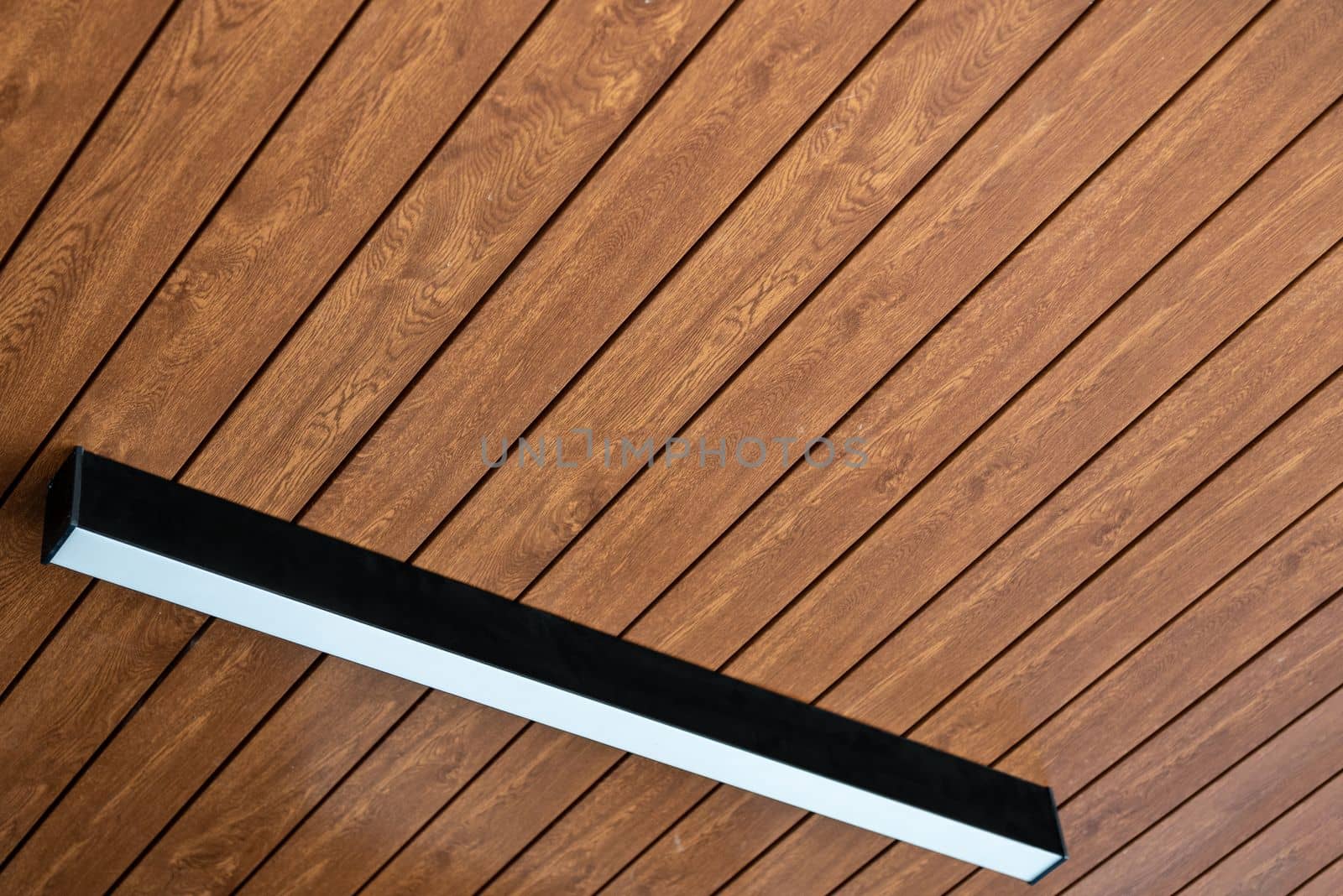 PVC ceiling panel covered with wood-like vinyl with modern lighting installed on it