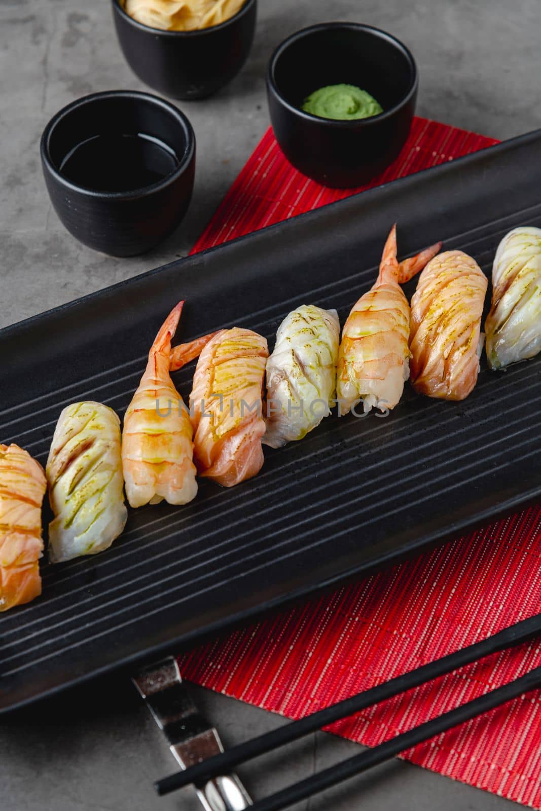 Sushi set of various products on a black stone plate