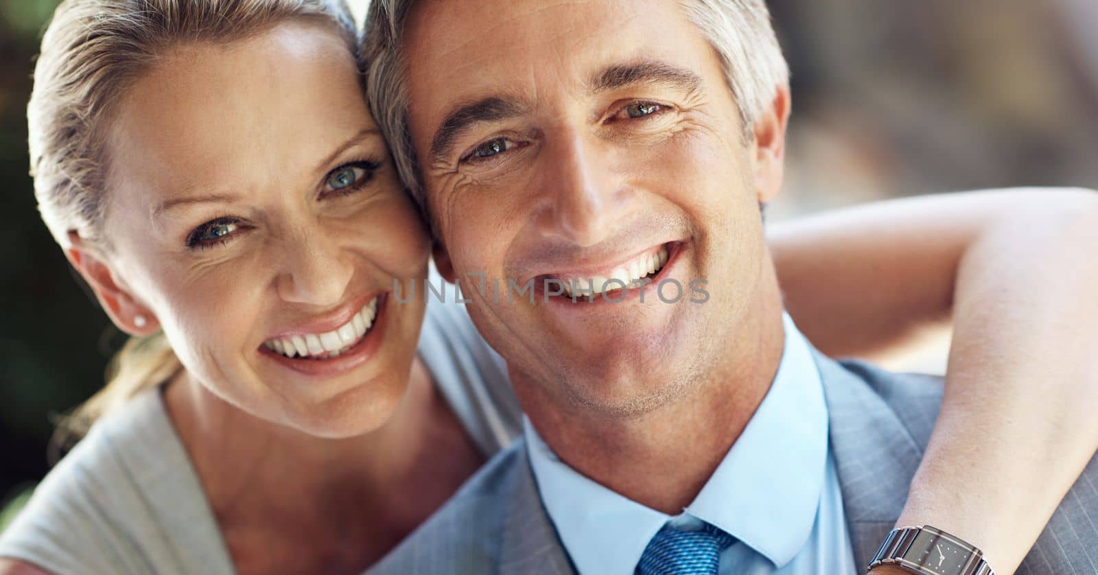 It takes two to tango towards success. Cropped portrait of an affectionate mature business couple smiling and holding each other closely in front of the camera. by YuriArcurs