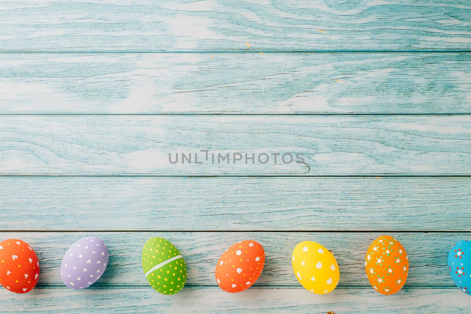 Happy Easter Day Concept. Top view holiday banner background web design white colorful easter eggs painted on blue wood background with empty copy space, celebration greeting card, overhead, template