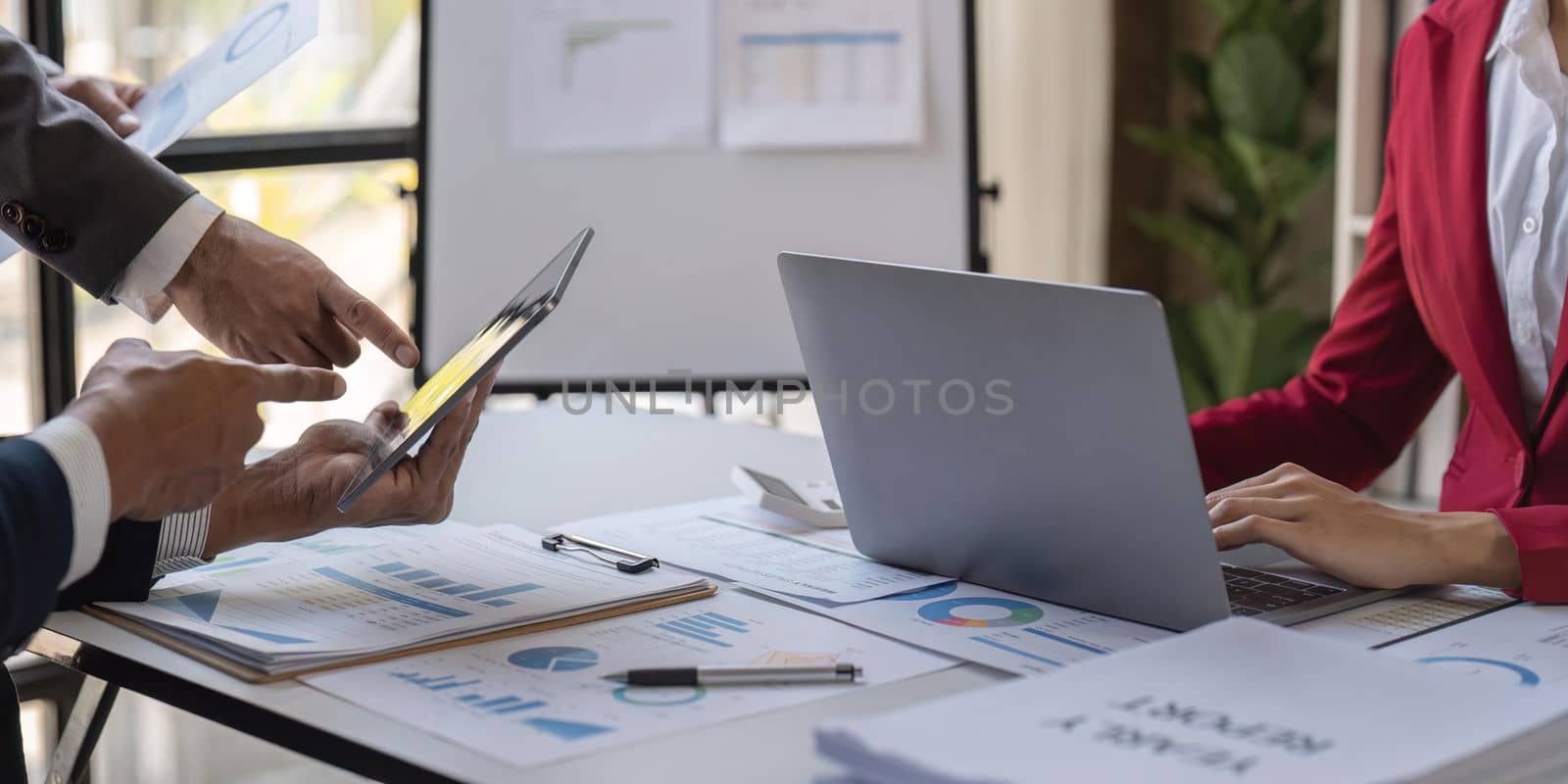 Team of business investment consultant analyzing company annual financial report working with documents pie and donut chart, using laptop and tablet, Business and Financial concept.